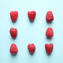 Photo of Frame of delicious ripe raspberries on light blue background, flat lay. Space for text