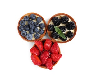 Tartlets with different fresh berries isolated on white, top view. Delicious dessert