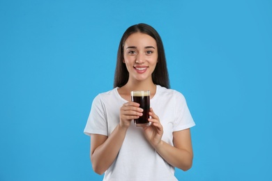 Photo of Beautiful woman with cold kvass on blue background. Traditional Russian summer drink