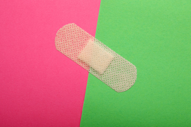 Photo of Sticking plaster on color background, top view