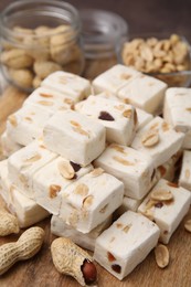 Photo of Pieces of delicious nutty nougat on table, closeup