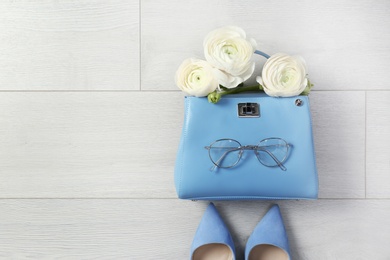 Photo of Flat lay composition with stylish bag and spring flowers on wooden background. Space for text