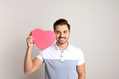 Photo of Portrait of young man with decorative heart on light background