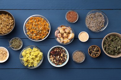 Photo of Many different dry herbs, flowers and seeds on blue wooden table, flat lay