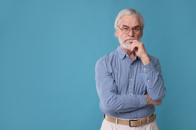 Photo of Portrait of stylish grandpa with glasses on light blue background, space for text