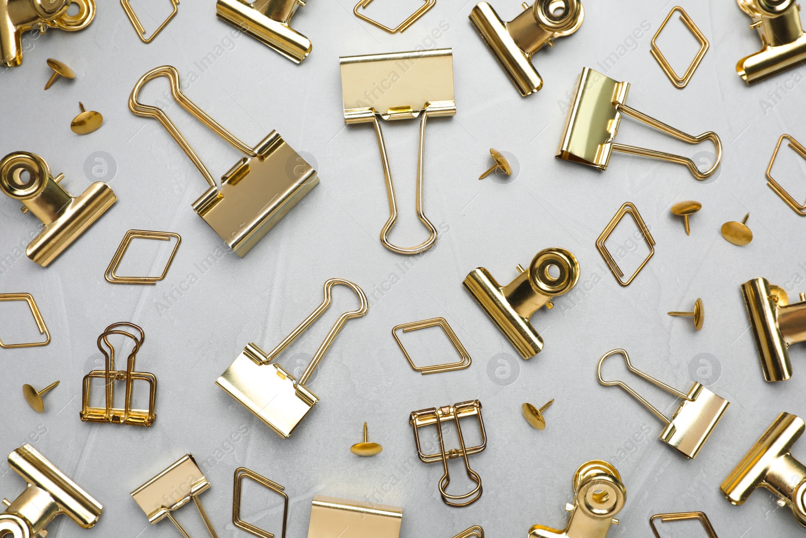 Photo of Flat lay composition with golden binder clips on light grey background