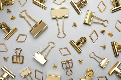 Photo of Flat lay composition with golden binder clips on light grey background
