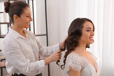 Photo of Stylist working with client in salon, making wedding hairstyle