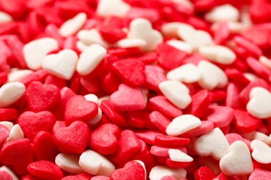 Photo of Sweet candy hearts as background, closeup view