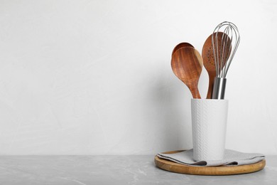 Photo of Set of kitchen utensils on light grey marble table. Space for text