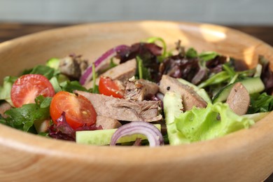 Delicious salad with beef tongue and vegetables in bowl, closeup