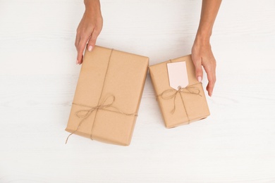 Photo of Woman holding parcels on wooden background, top view