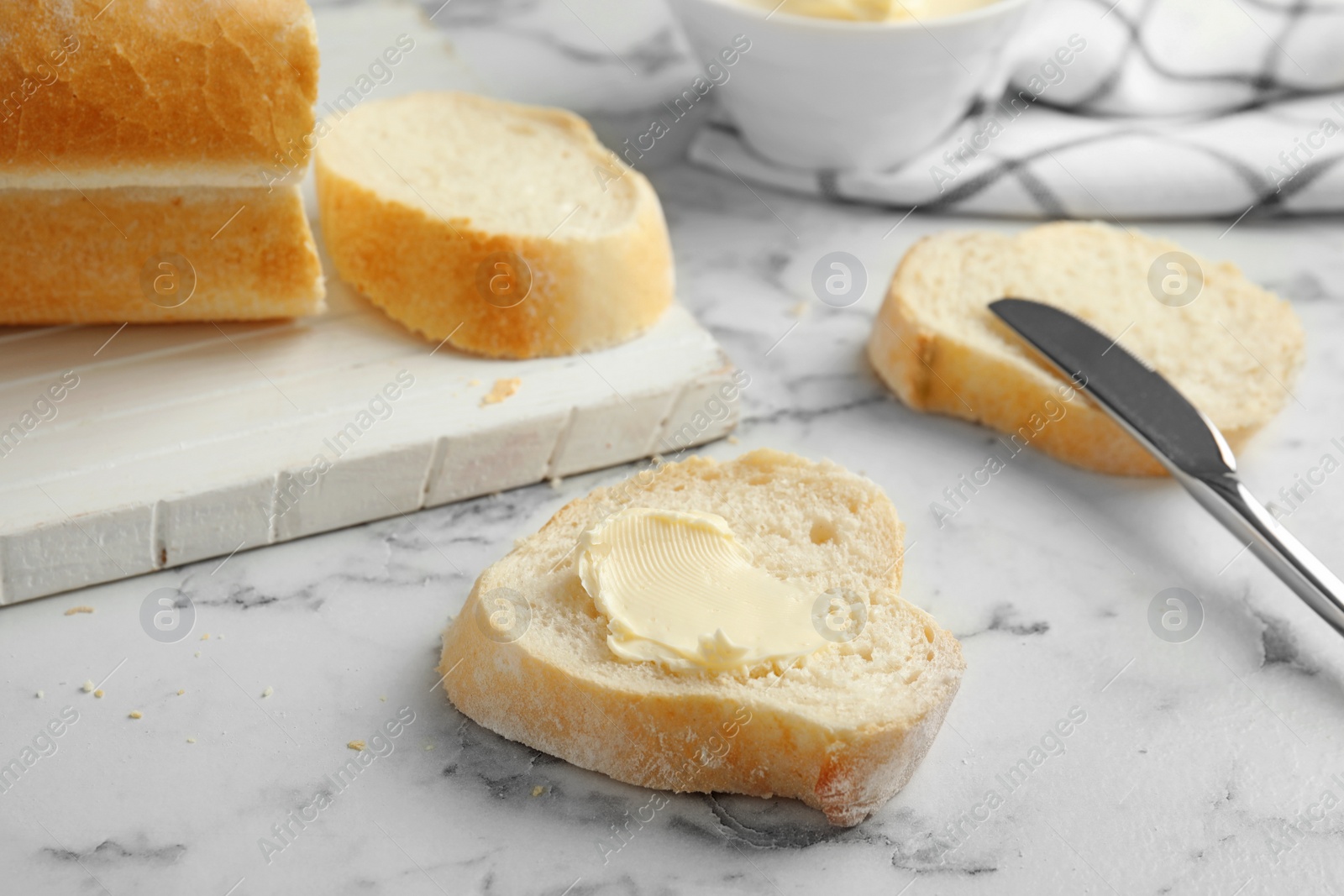 Photo of Slice of bread with butter on marble table