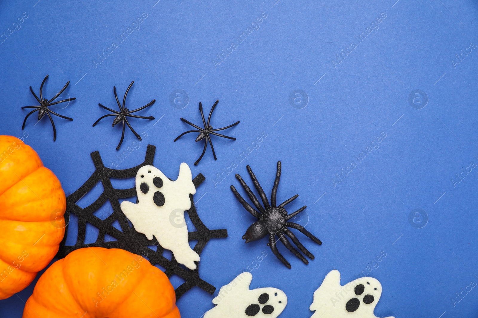 Photo of Flat lay composition with Halloween decor on blue background, space for text