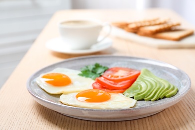 Photo of Plate with fried eggs and vegetables on wooden table. Healthy breakfast