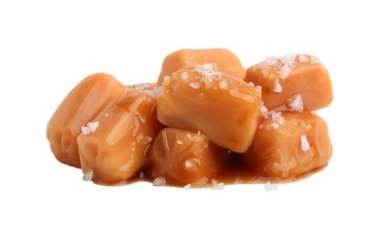 Photo of Yummy caramel candies and sea salt isolated on white