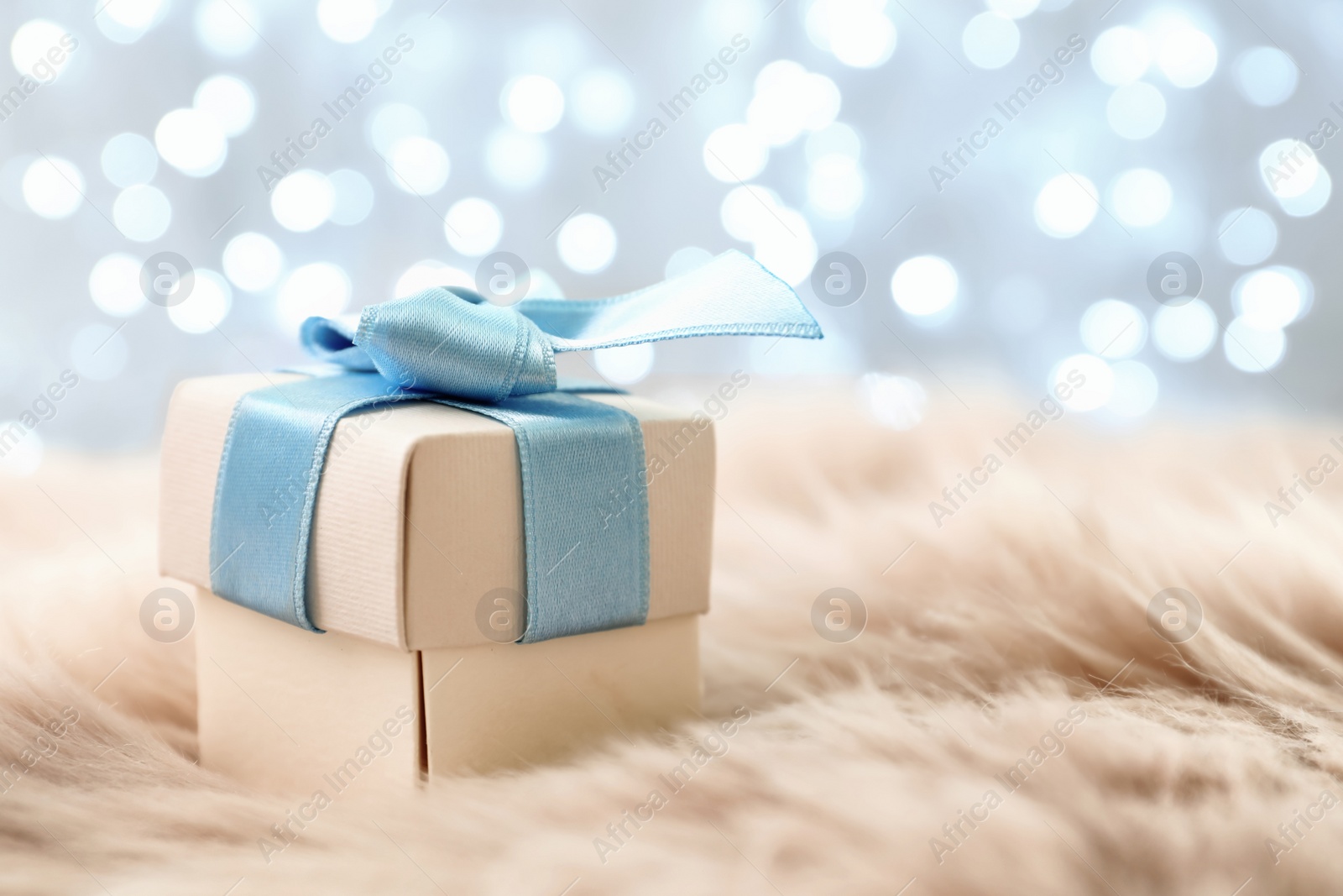 Photo of Christmas gift on fur against blurred background