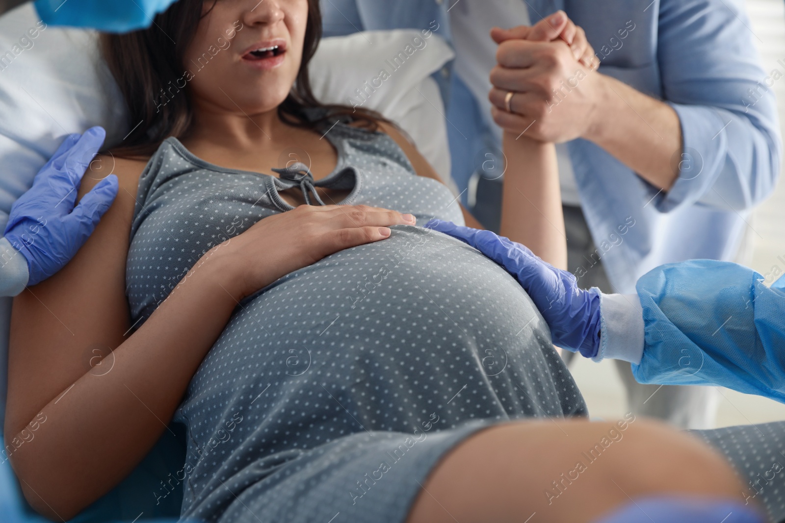 Photo of Woman giving child birth in maternity hospital, closeup