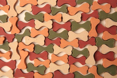 Photo of Flat lay composition with many bone shaped vitamins for pets on beige background