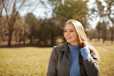 Portrait of beautiful young woman in city park on sunny day