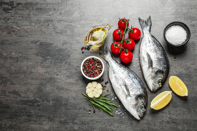 Photo of Flat lay composition with raw dorada fish on grey table, space for text