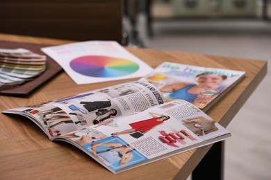 Photo of Different lifestyle magazines on wooden table indoors