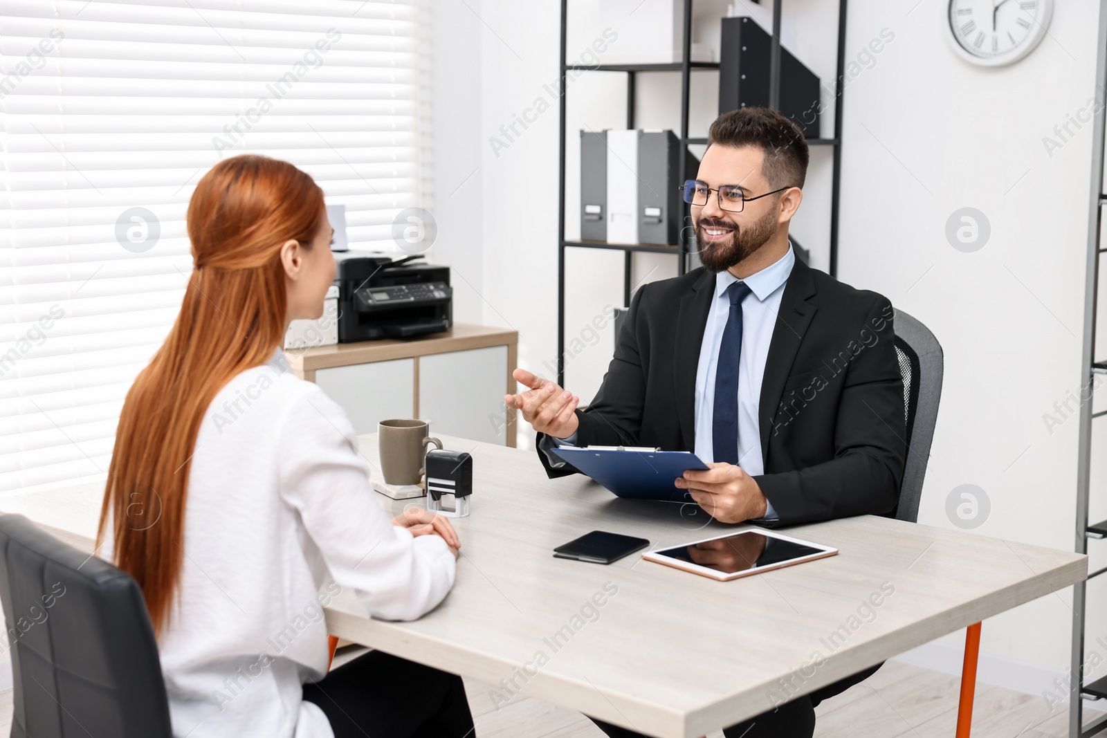 Photo of Immigration. Woman having interview with embassy worker in office