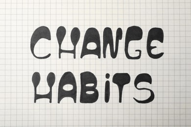 Photo of Phrase Change Habits written on gridded paper, top view