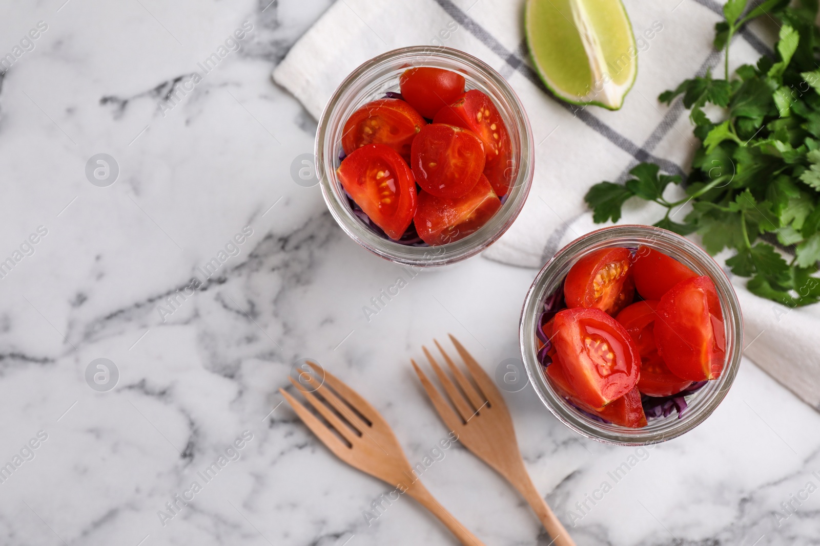 Photo of Healthy salad in glass jars on marble table, flat lay