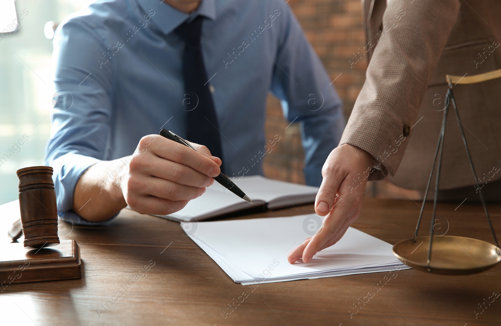 Photo of Notaries working with papers at table in office, closeup. Law and justice concept