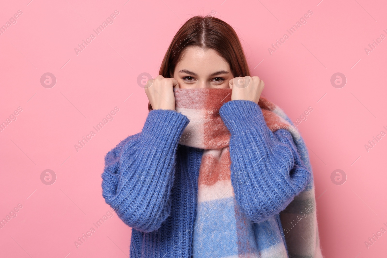 Photo of Beautiful woman in warm scarf on pink background