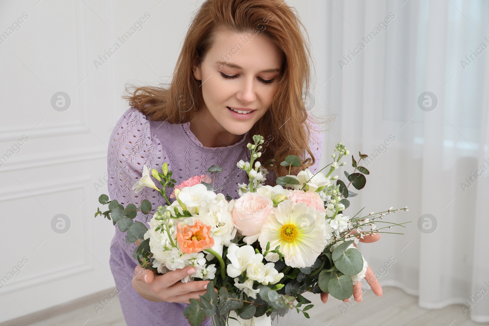 Photo of Beautiful woman with bouquet of flowers indoors