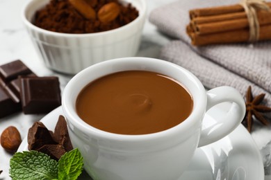 Photo of Yummy hot chocolate in cup on white table, closeup