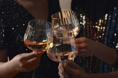 Image of Women clinking glasses with white wine, closeup