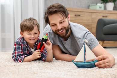 Photo of Happy dad and son playing toys together at home