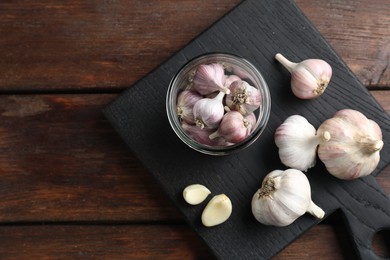 Photo of Many fresh garlic bulbs on wooden table, top view. Space for text