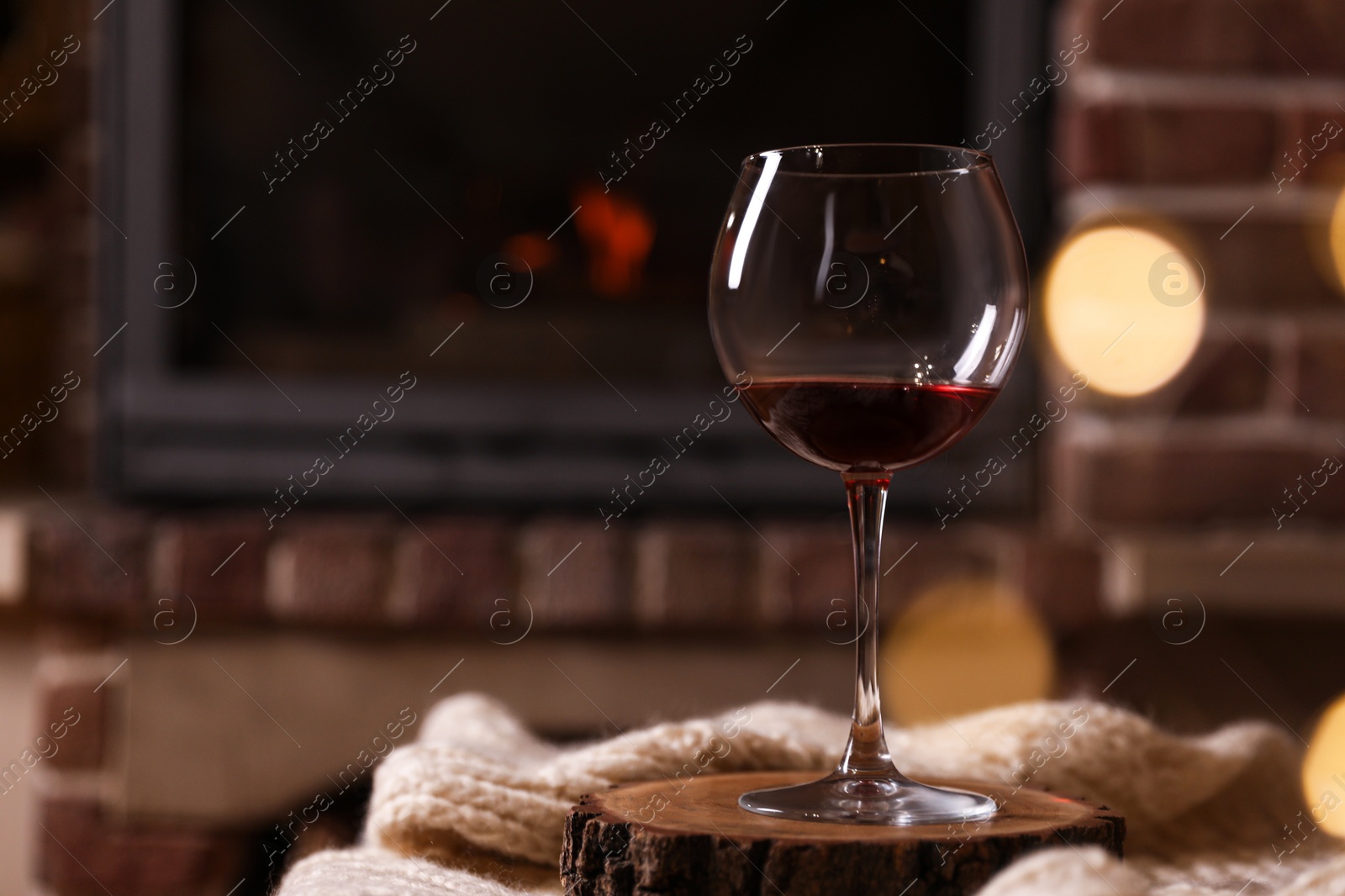 Photo of Glass of wine near fireplace indoors. Space for text