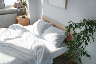 Photo of Large comfortable bed with soft pillows and blanket indoors