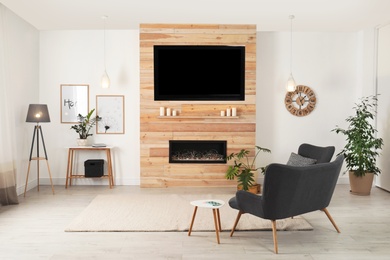 Photo of Living room interior with decorative fireplace in wooden wall