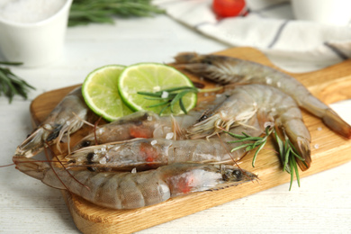Photo of Fresh raw shrimps on white wooden table