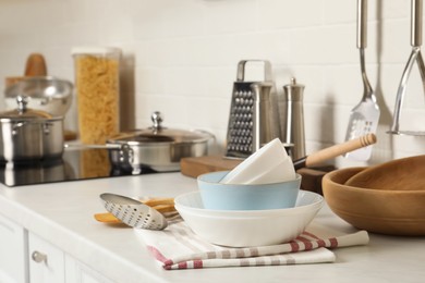 Photo of Stack of bowls and different cooking utensils on kitchen counter