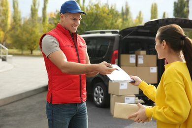 Photo of Courier receiving receipt signature from customer outdoors