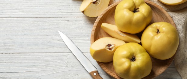 Image of Fresh ripe organic quinces and knife on white wooden table, flat lay with space for text. Banner design