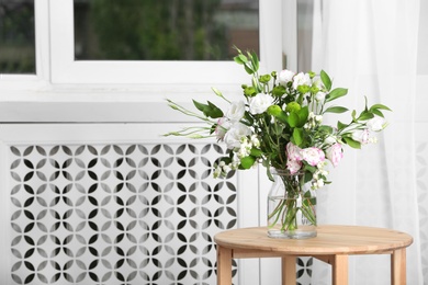 Photo of Glass vase with bouquet of beautiful flowers on table in room. Space for text