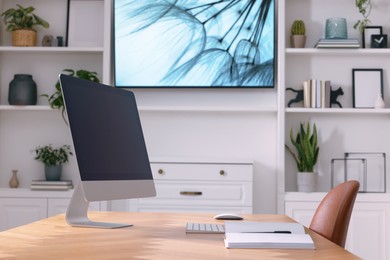 Photo of Cosy workplace with computer near tv area. Interior design