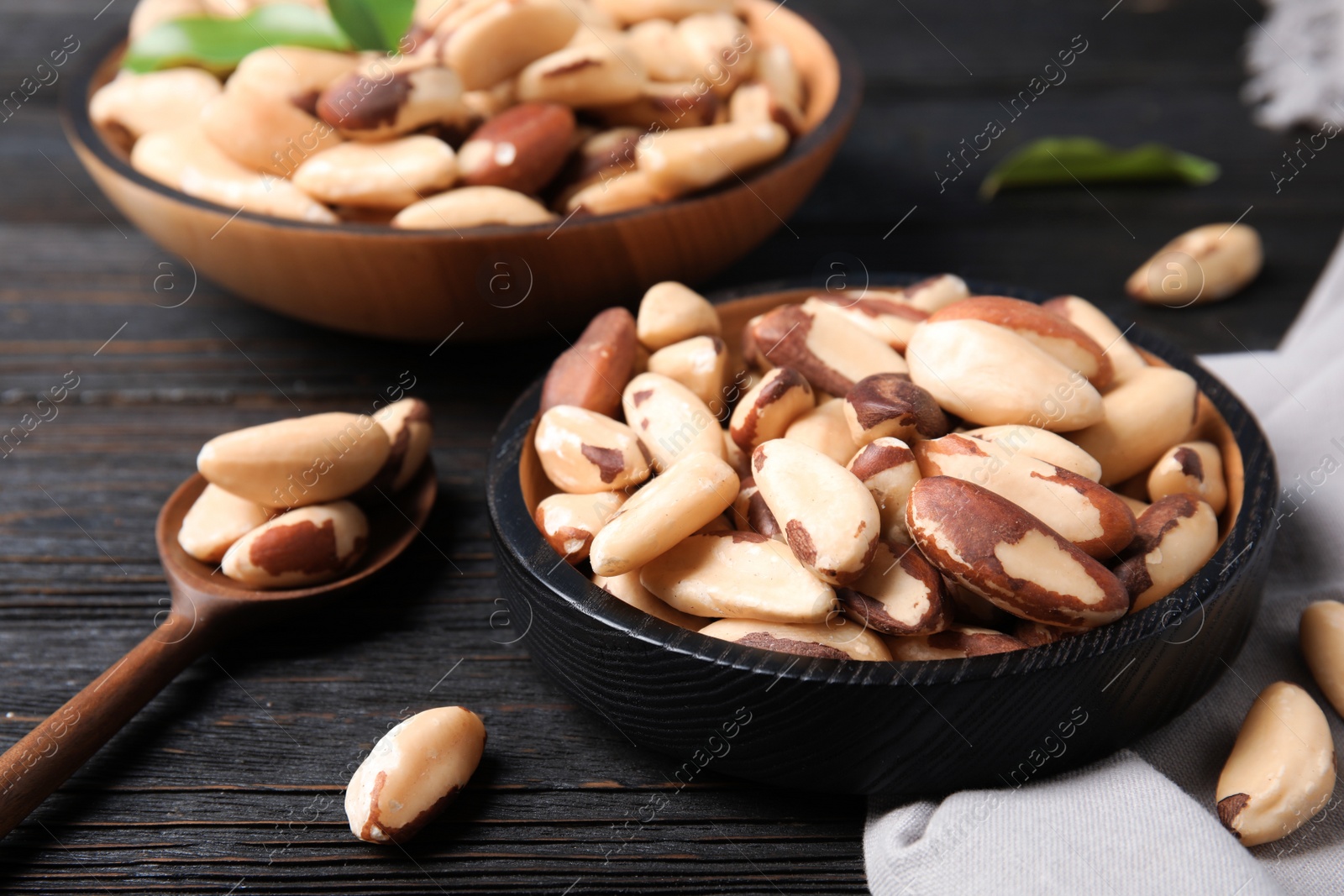 Photo of Plate with tasty Brazil nuts on wooden table