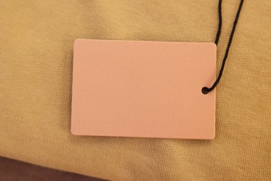 Photo of Cardboard tag on garment, closeup. Space for text