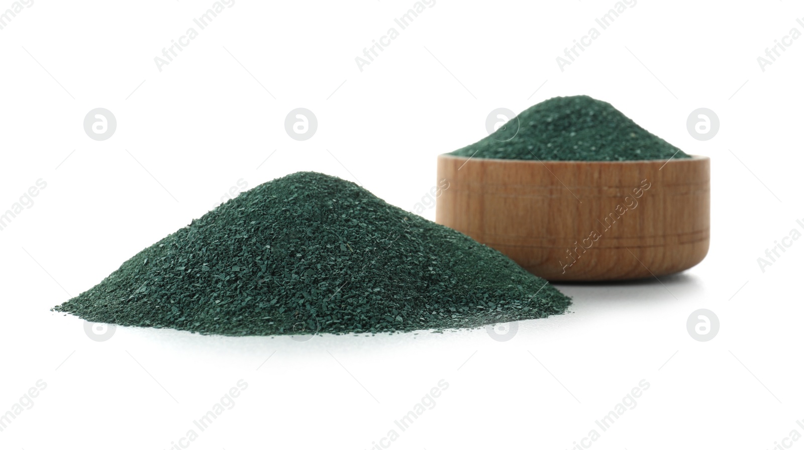 Photo of Bowl and heap of spirulina algae powder on white background