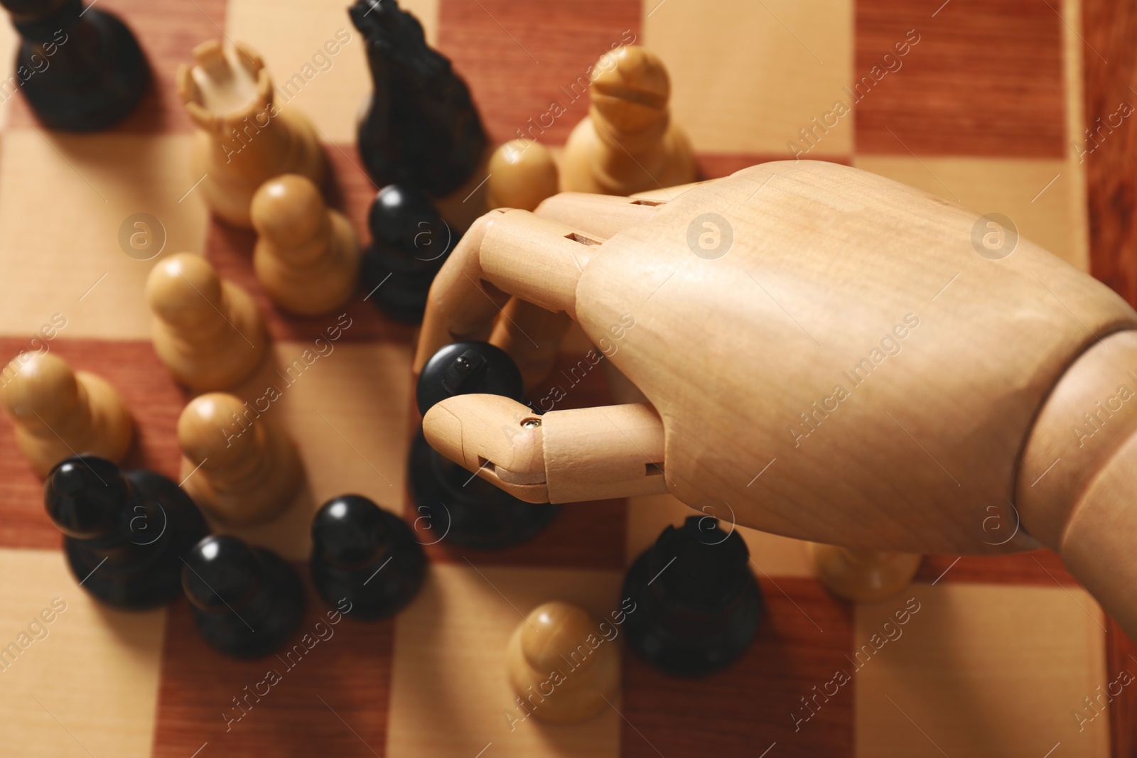 Photo of Robot moving chess piece on board, above view. Wooden hand representing artificial intelligence