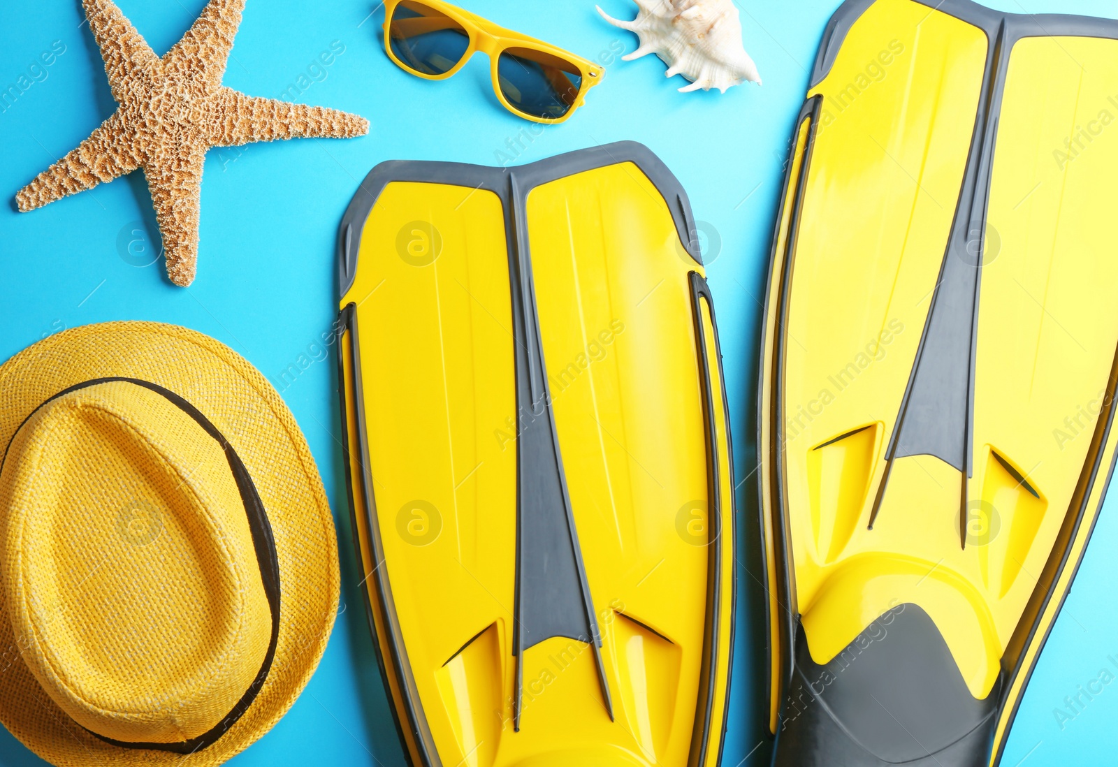 Photo of Flat lay composition beach accessories on light blue background
